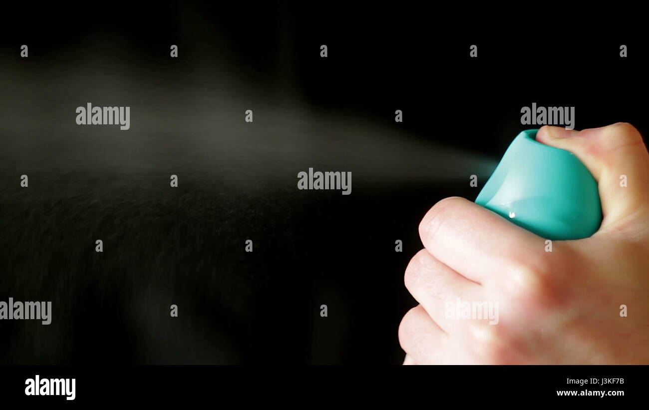 Aerosol can being sprayed against a black background Stock Photo - Alamy