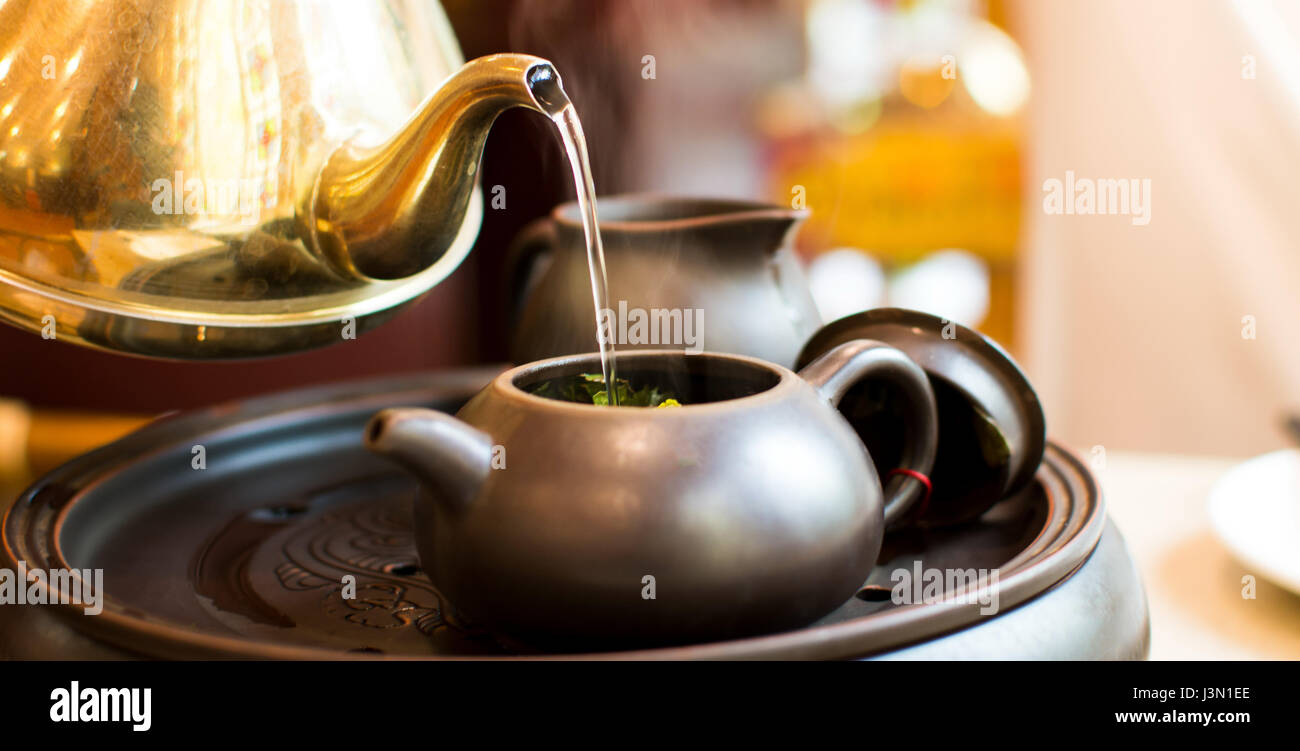 Hot Water Pouring Into Ceramic Teapot For Making A Tea Stock Photo Alamy