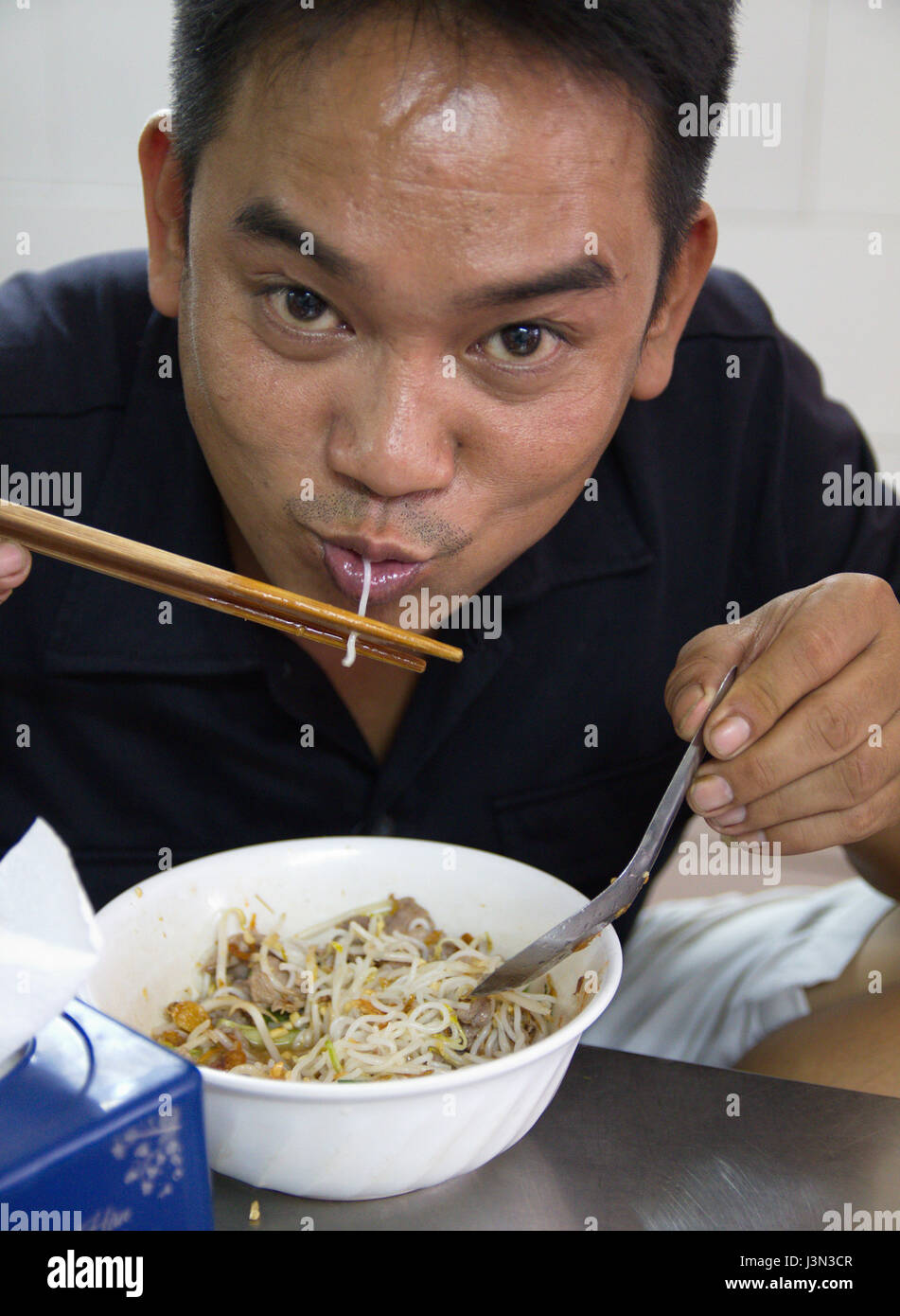 Vietnamese man eating noodles in a noodle restaurant in Hanoi, Vietnam Stock Photo