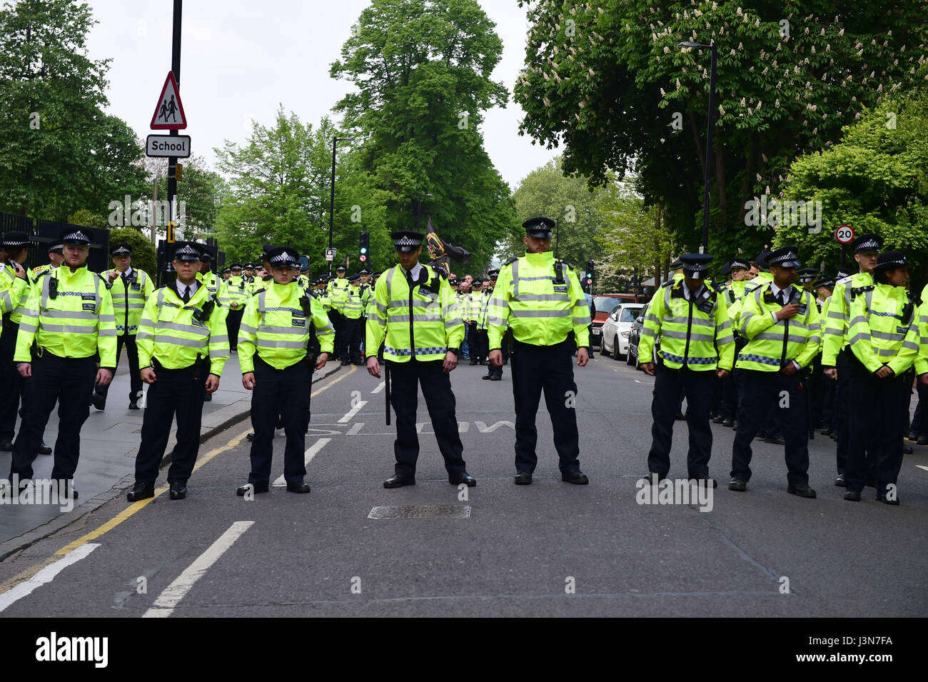 Police block a road as two groups of protesters demonstrate for and against immigration near Lunar House in Croydon, the headquarters of the Home Office's UK Visas and Immigration division. Stock Photo