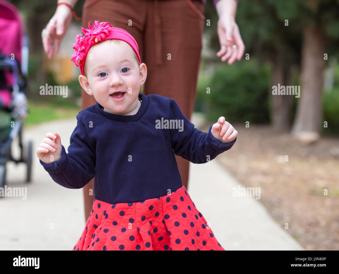 Adorable baby girl taking her first steps Stock Photo