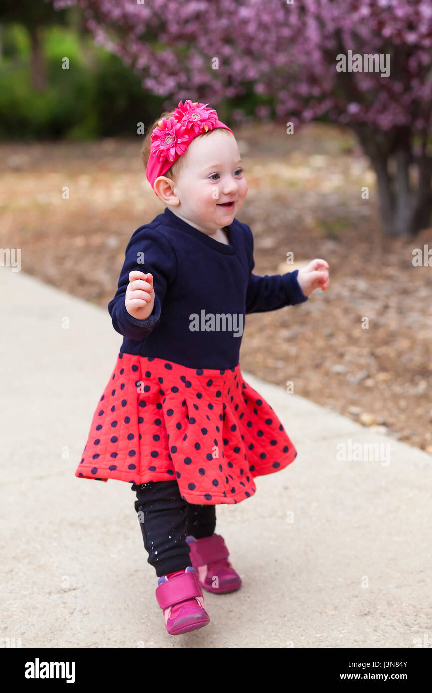 Adorable baby girl learning to balance on her feet Stock Photo