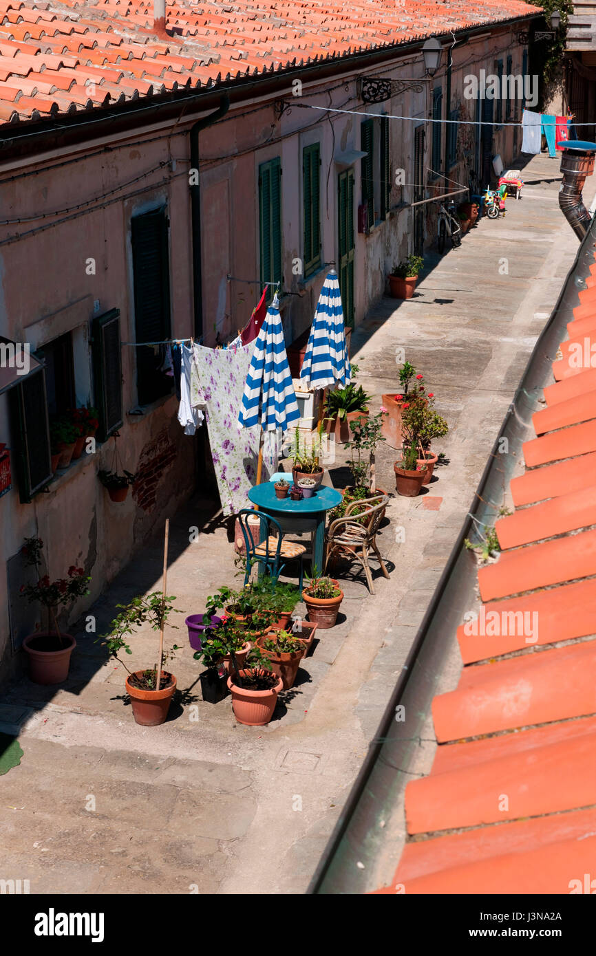 alley in historic city, flowerpots, sun umbrella, terracotta