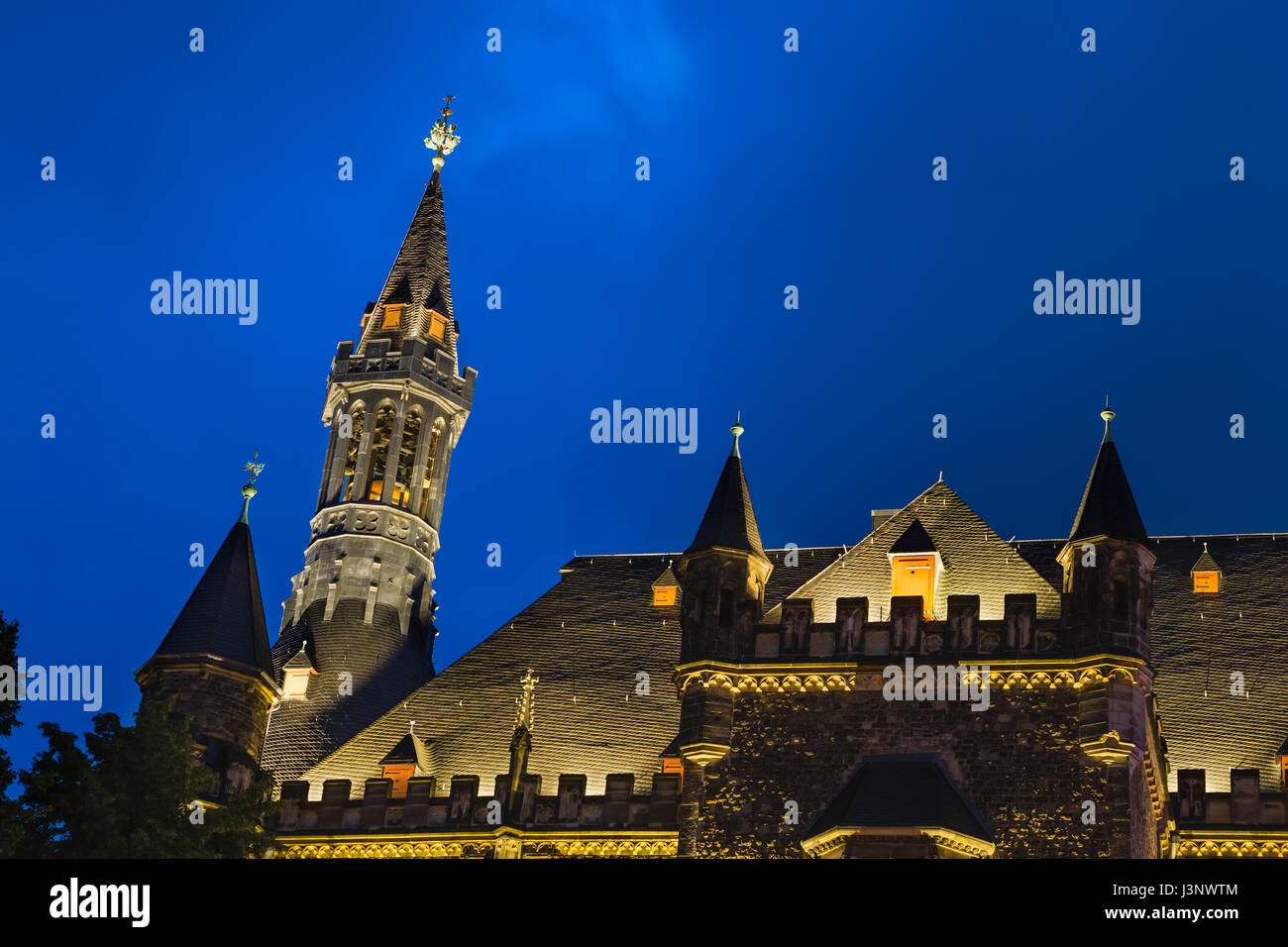 One of the towers of the old town hall of Aachen, Germany with night blue sky seen from the Katschhof. Stock Photo