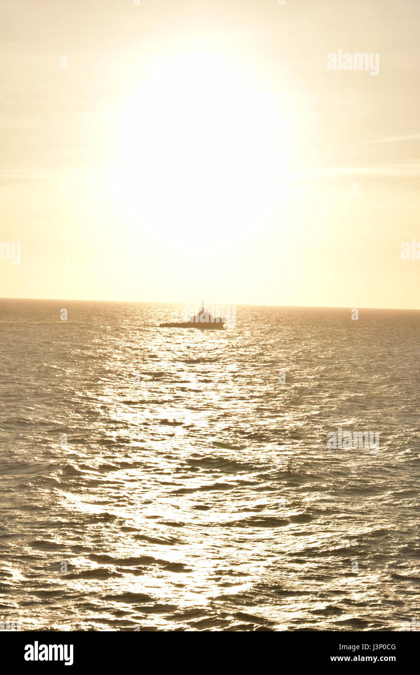 Alp Ace, sea going tug, silhouetted in evening sun, Atlantic Ocean off Portugal Stock Photo