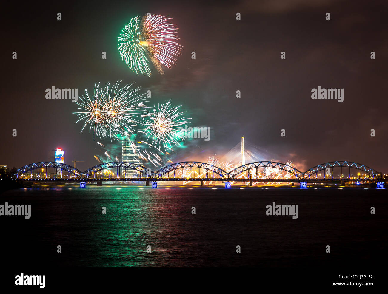 Firework in Riga over the river with bridge at night Stock Photo