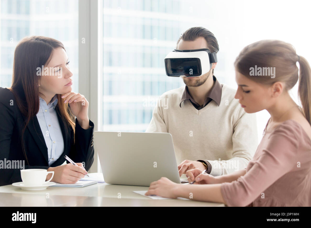 Business team testing VR-ready laptop, developing virtual realit Stock Photo