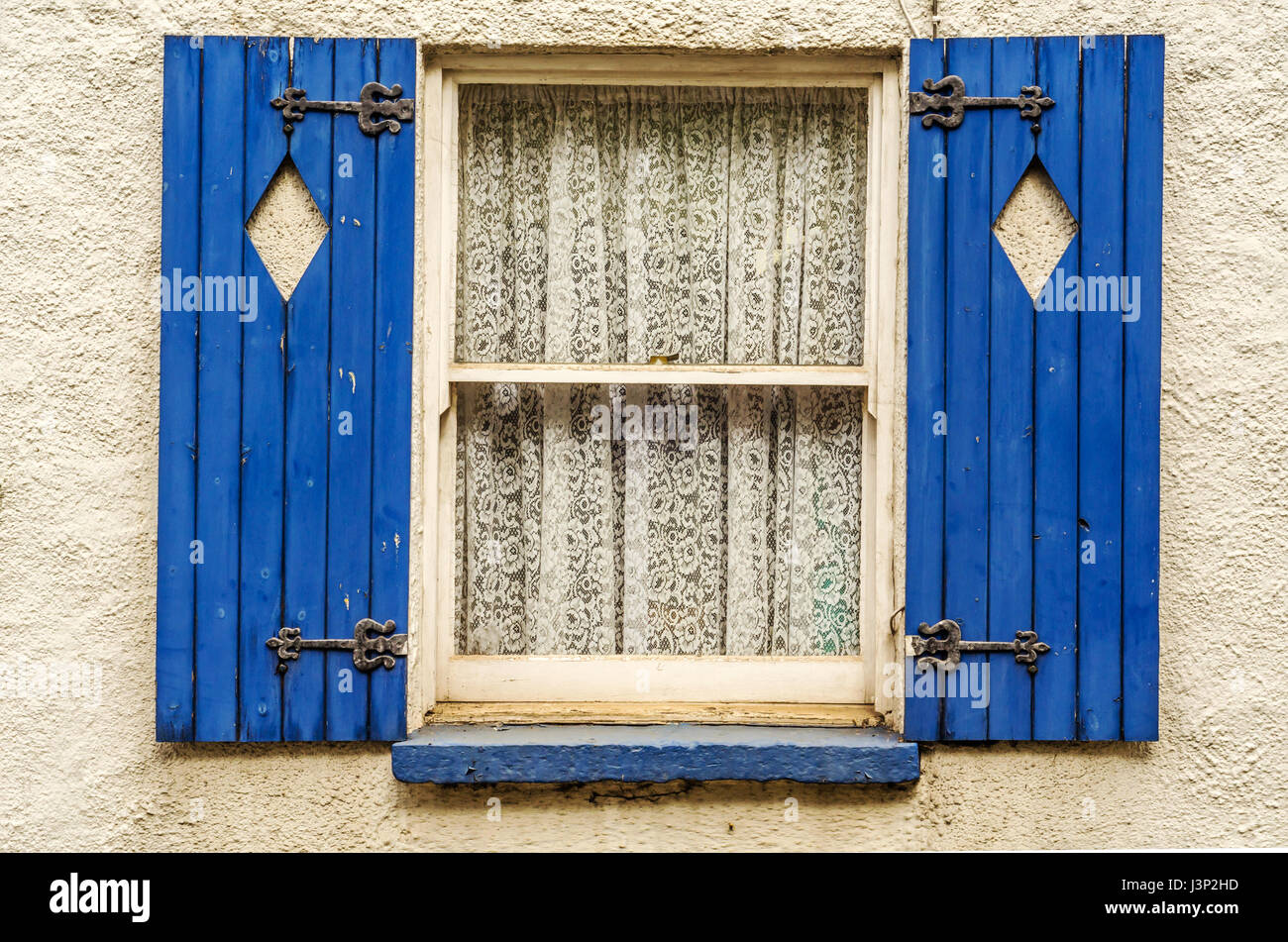 Window with wooden shutters, diamond shape cut in shutters, shutters