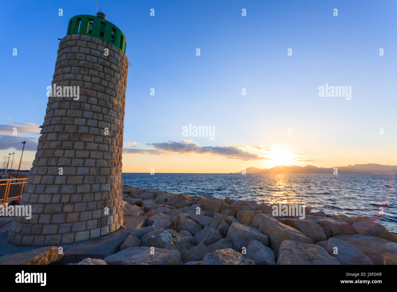 Sunset from the port of Cannes, France. Beautiful french panorama. Sun over Esterel mountains Stock Photo