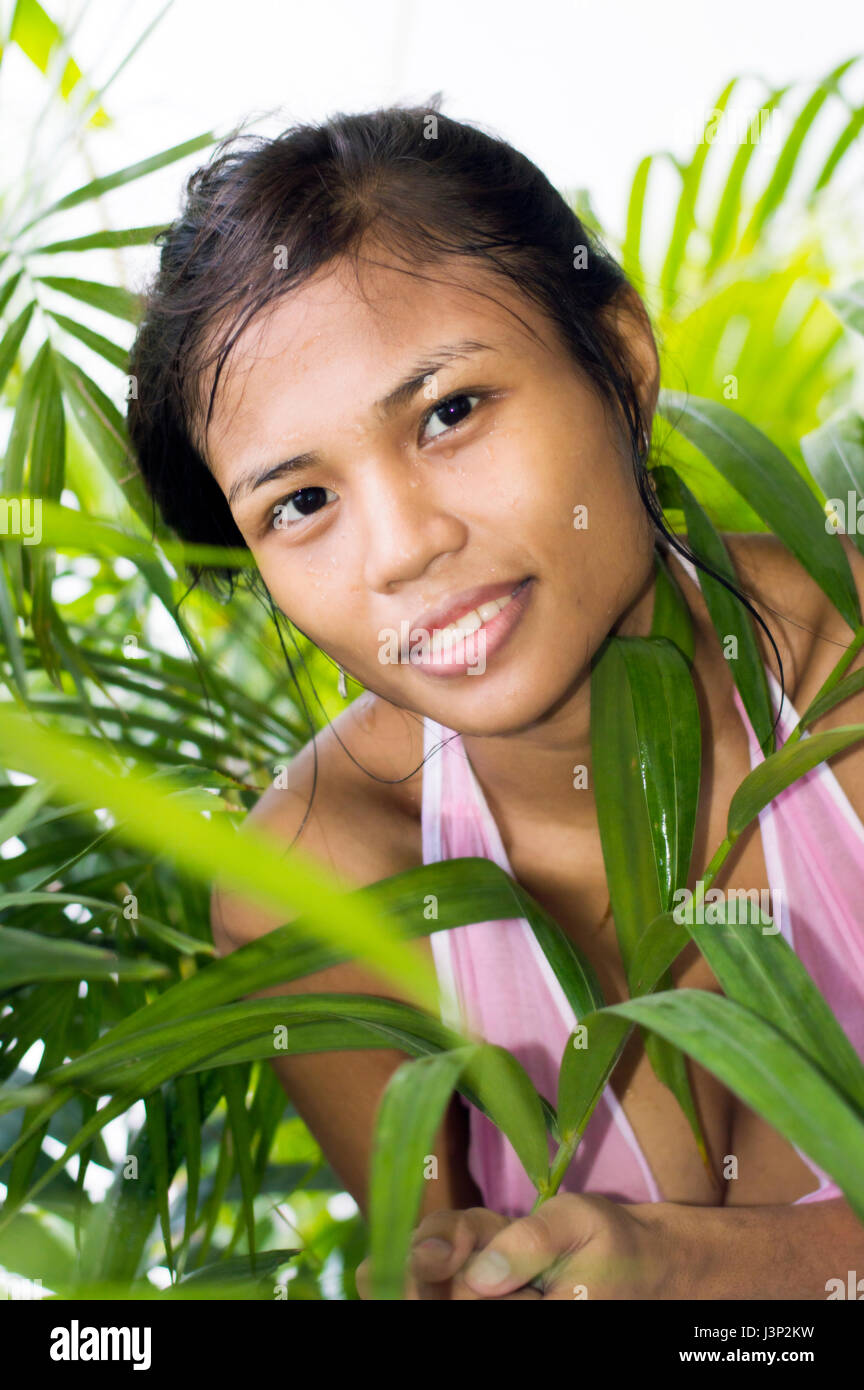 Young attractive Asian woman amidst tropical foliage Stock Photo