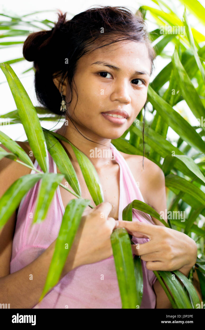 Young attractive Asian woman amidst tropical foliage Stock Photo