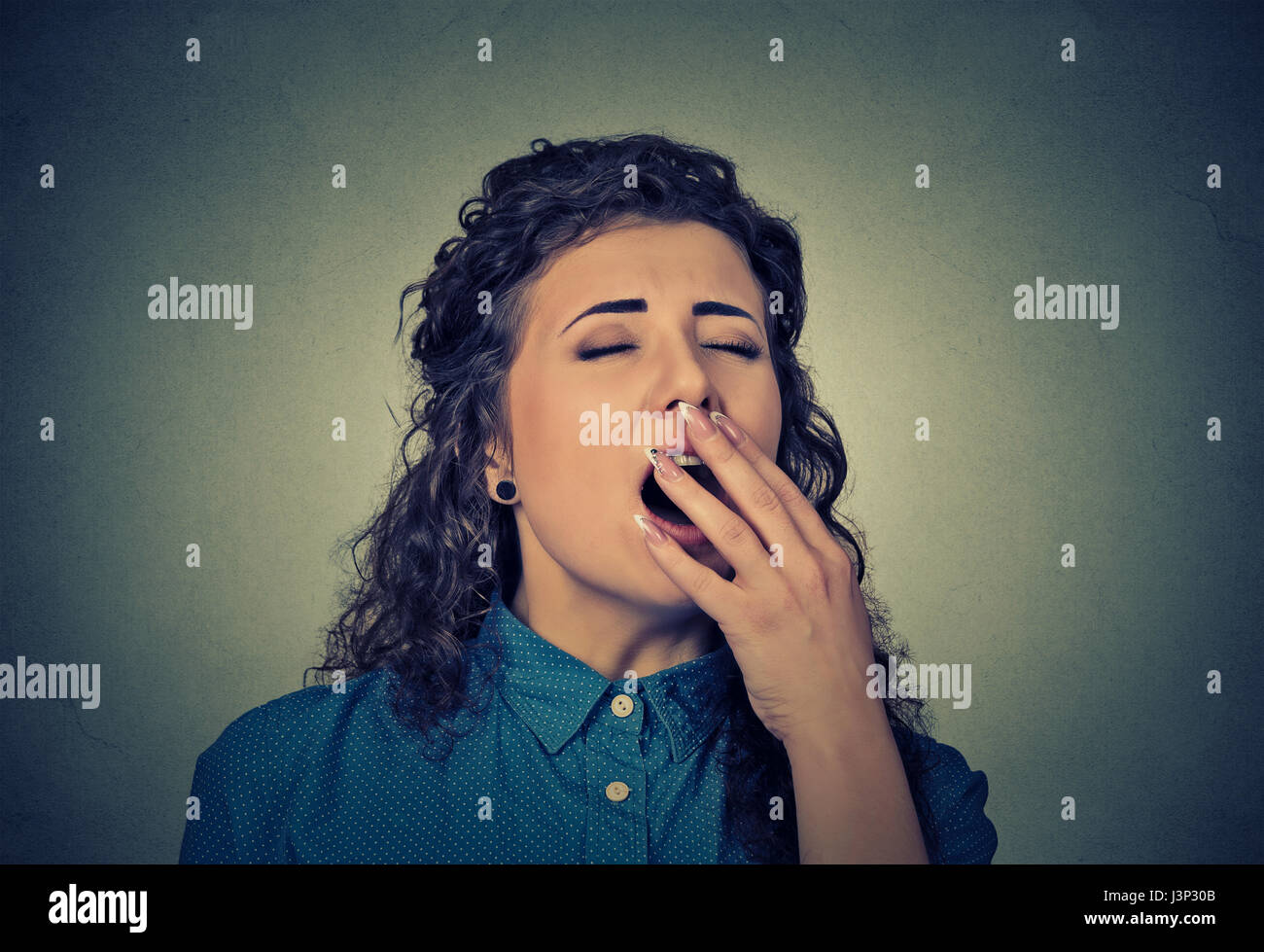It is too early for meeting. Closeup portrait sleepy young woman with wide open mouth yawning eyes closed looking bored isolated on gray wall backgrou Stock Photo