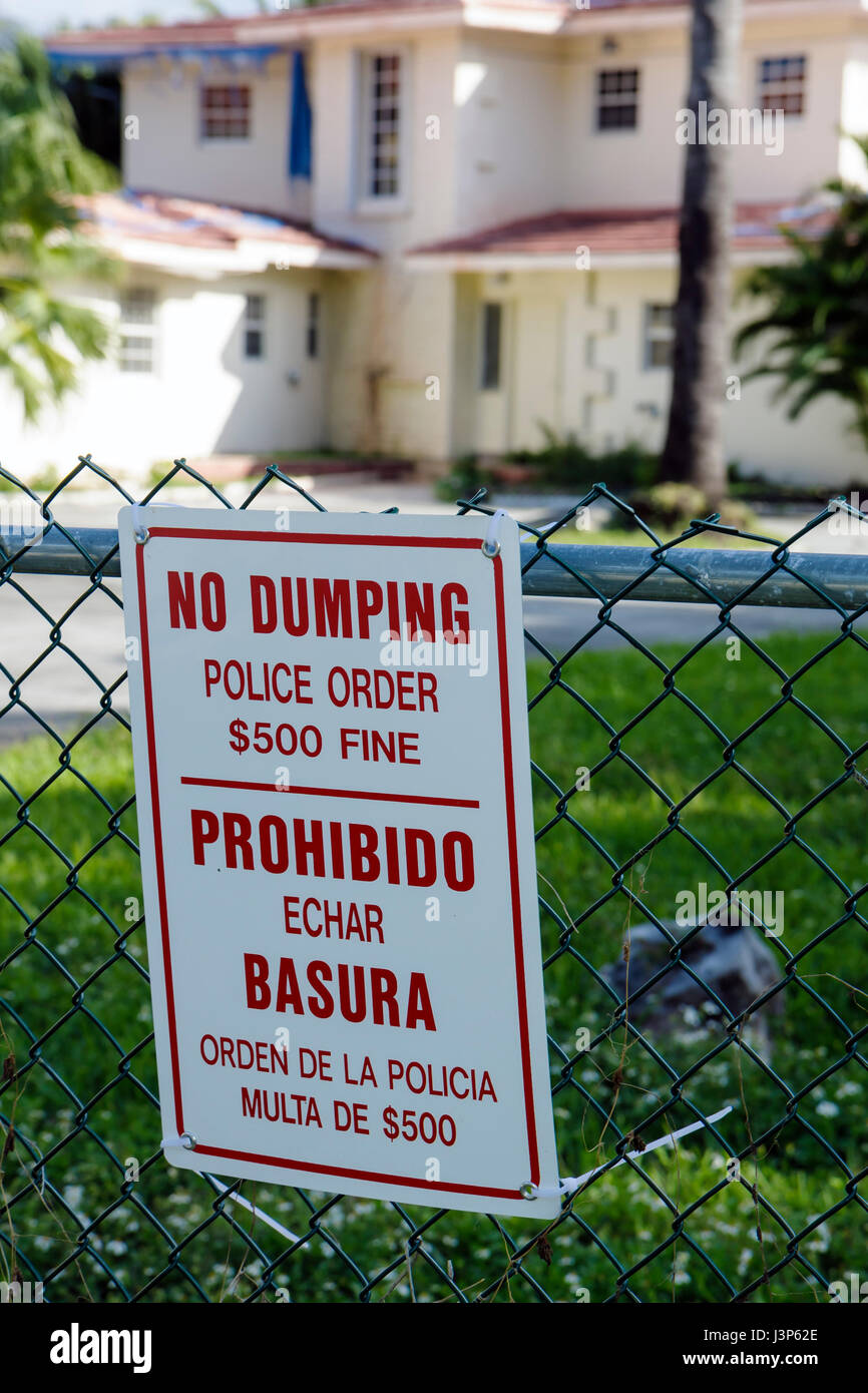 Miami Beach Florida,sign,warning,police fine,no dumping,dumping,trash,abandoned home,English,Spanish language,bilingual,FL081123118 Stock Photo