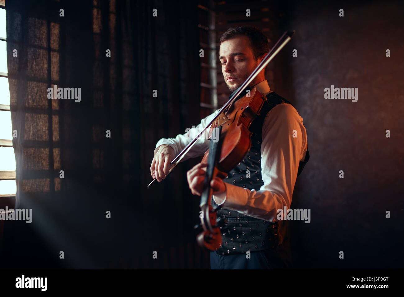 Portrait of male fiddler playing classical music on violin. Violinist