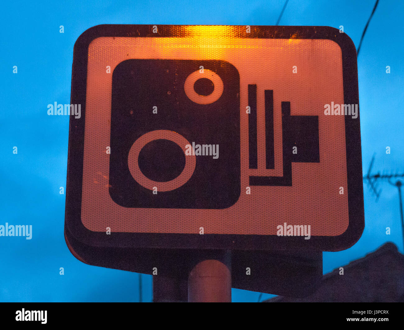 a sign outside at night of cameras for speeding Stock Photo