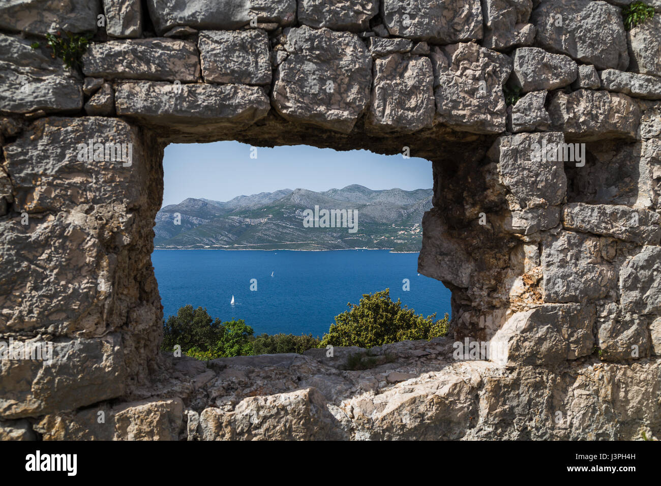 Looking through a lookout point in the ruins of Sutvrac Fort on Lopud Island towards the Croatian mainland. Stock Photo