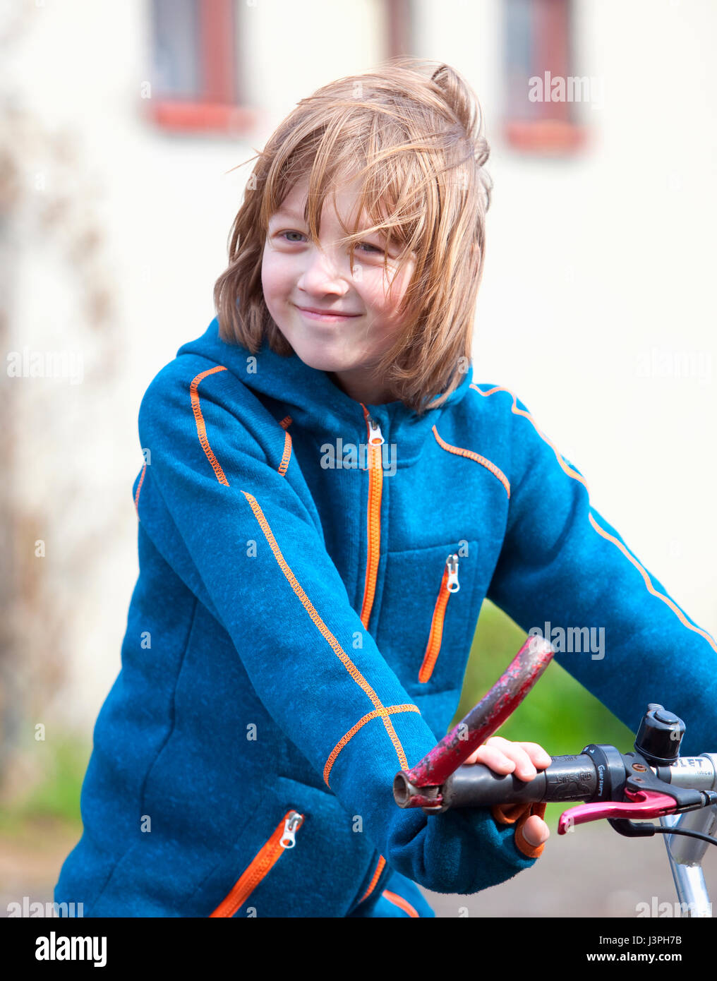 Portrait of a Boy on Bike with Blond Hair Smiling Stock Photo