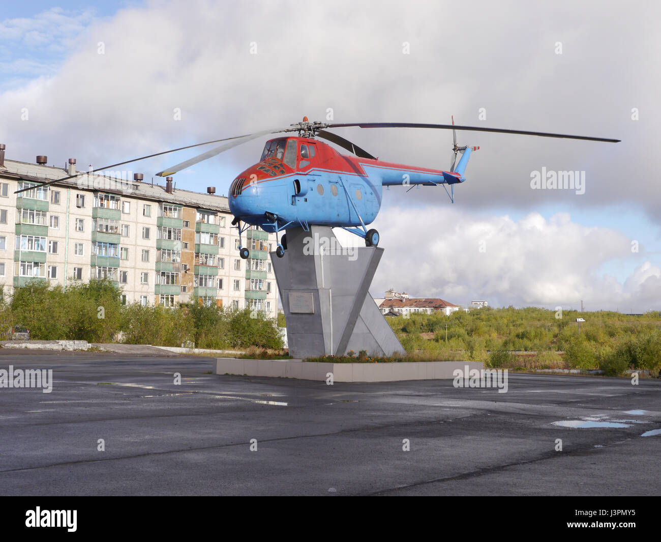 Old helicopter on pedestal in northern russia town with tundra landscape at background Stock Photo