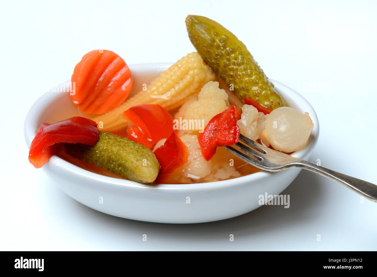Mixed pickles mit Moehren, Blumenkohl, Gurken, Zwiebeln und Maiskoelbchen in einer Schale mit Gabel, eingelegte, eingelegt Stock Photo