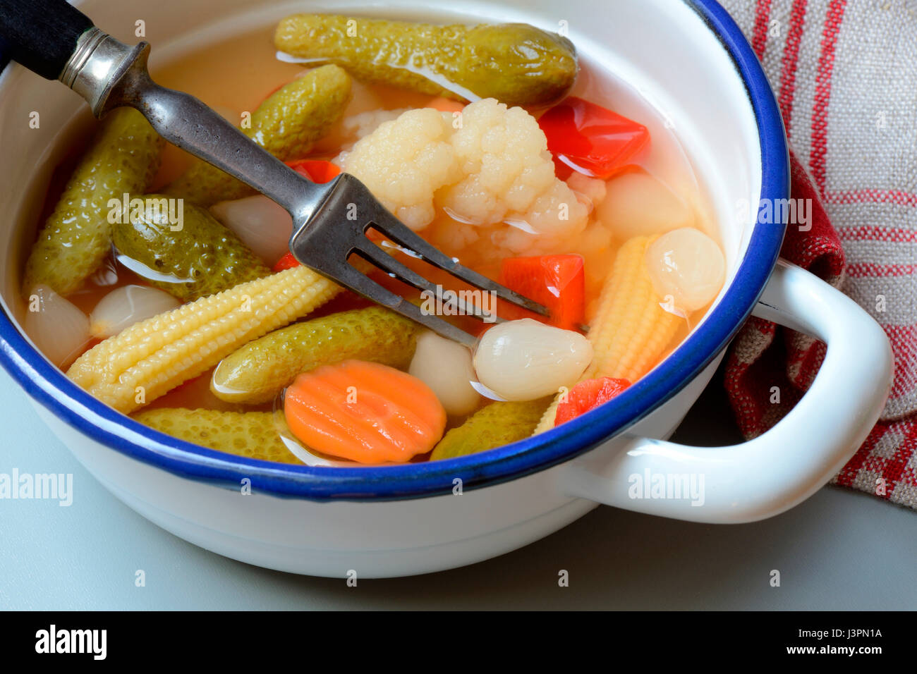 Mixed pickles mit Moehren, Blumenkohl, Gurken, Zwiebeln und Maiskoelbchen in einer Schale mit Gabel, eingelegte, eingelegt, Essiggurke, Essiggurken Stock Photo