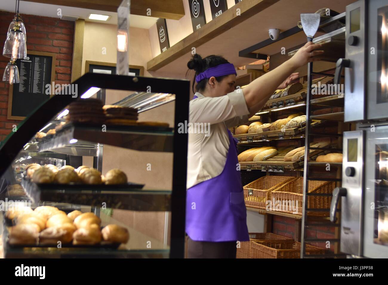 Bakery shop interior with female worker behind Stock Photo