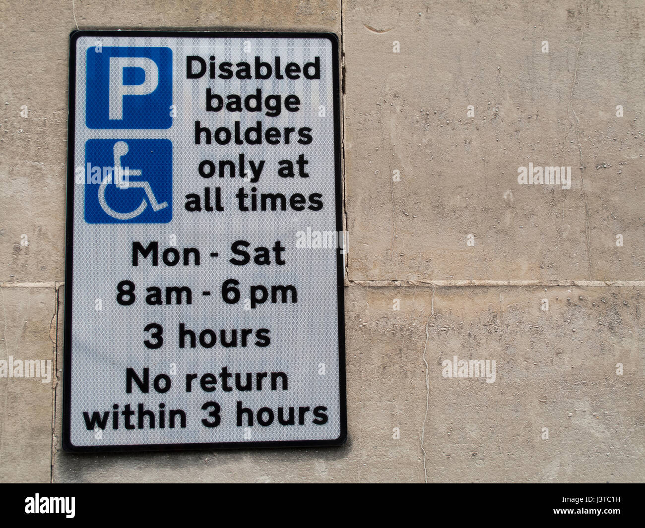 Disabled badge holders only at all times parking sign mounted on stone