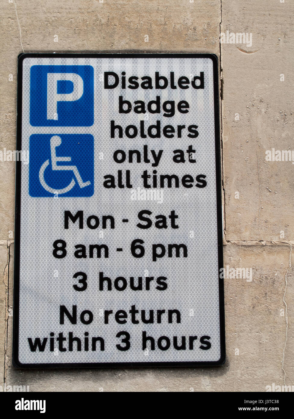 Disabled badge holders only at all times parking sign mounted on stone