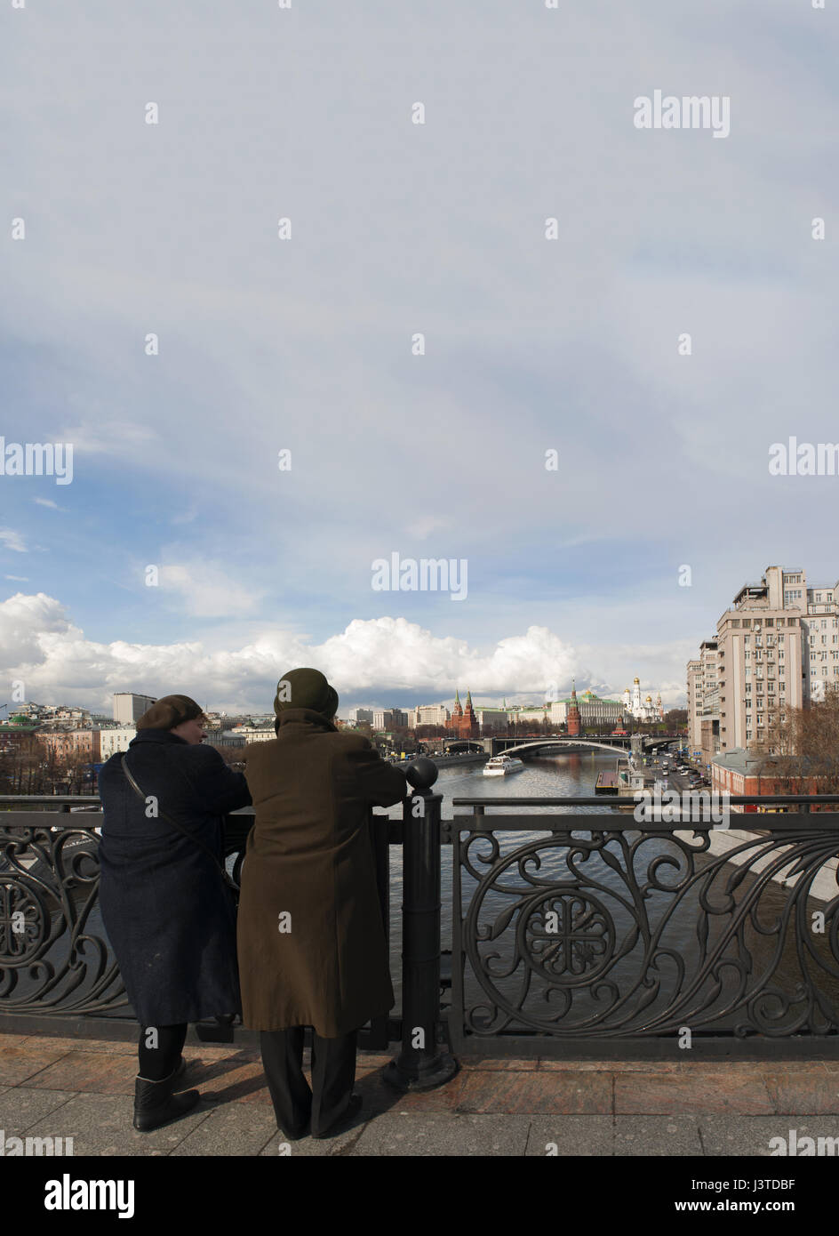 Two old Russian women looking the skyline of Moscow with view of the fortified complex of the Kremlin from the Patriarch Bridge on the Moskva River Stock Photo