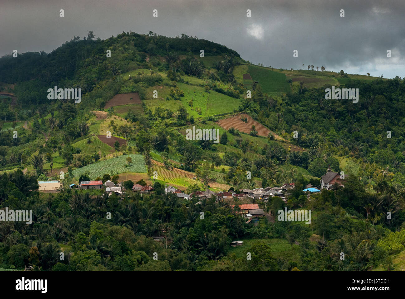 Agricultural settlement and hilly plantation landscape are seen from Rurukan village in East Tomohon, Tomohon, North Sulawesi, Indonesia. Stock Photo