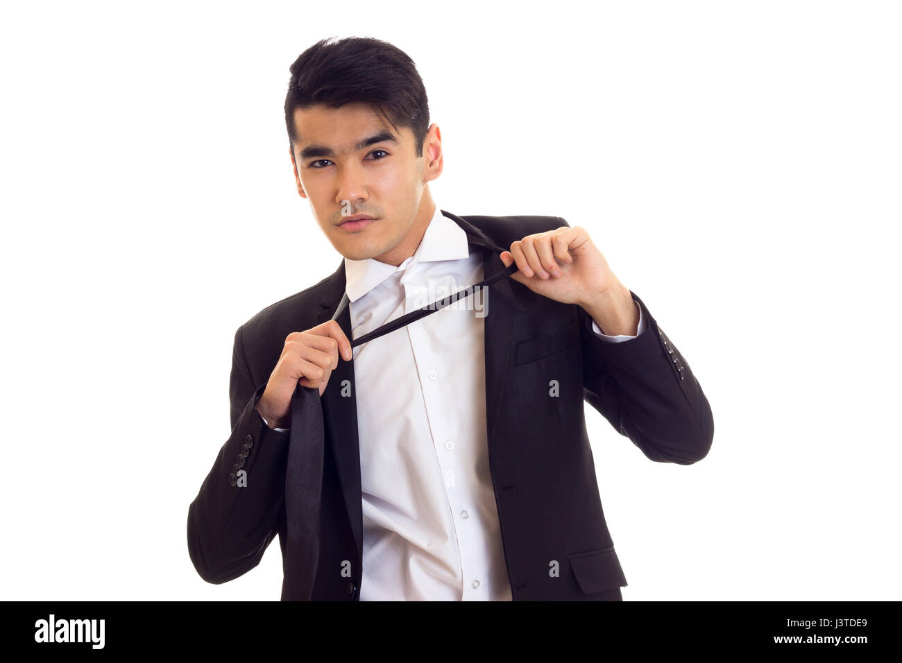 Young man in suit fixing his tie Stock Photo - Alamy