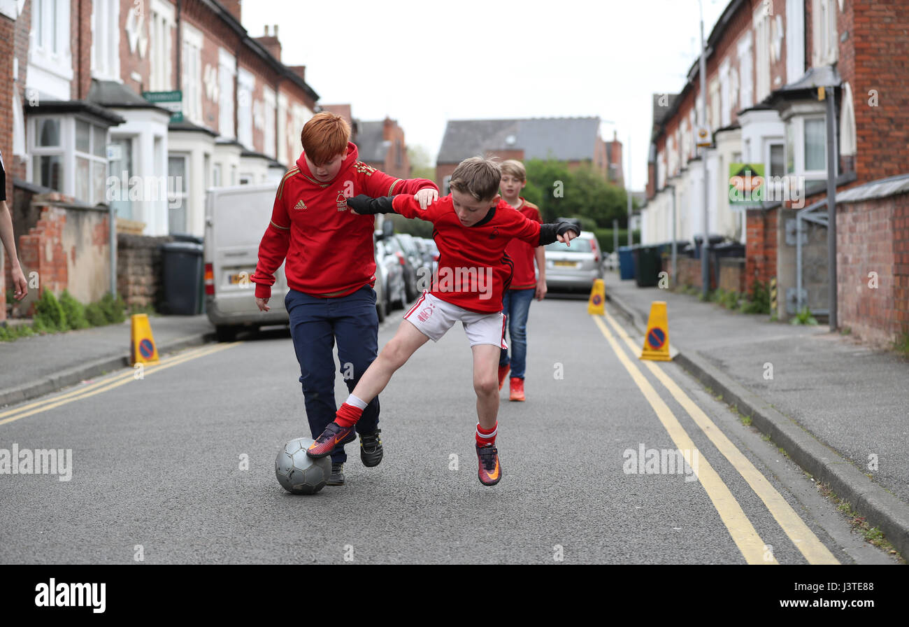 Children play football in the streets outside The City Ground before