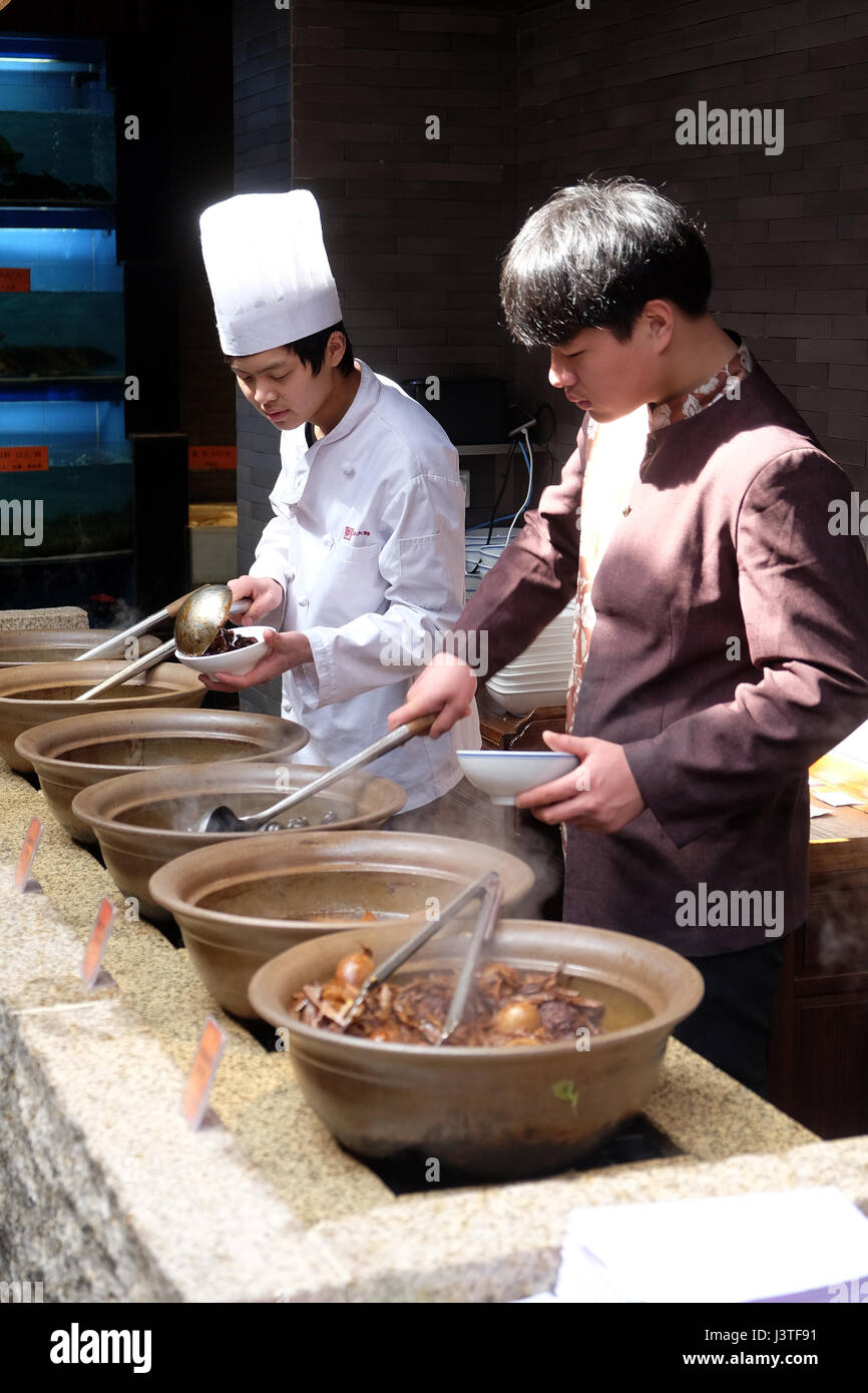 The chefs prepare traditional Chinese food at the restaurant on the Grand Canal, ancient town of