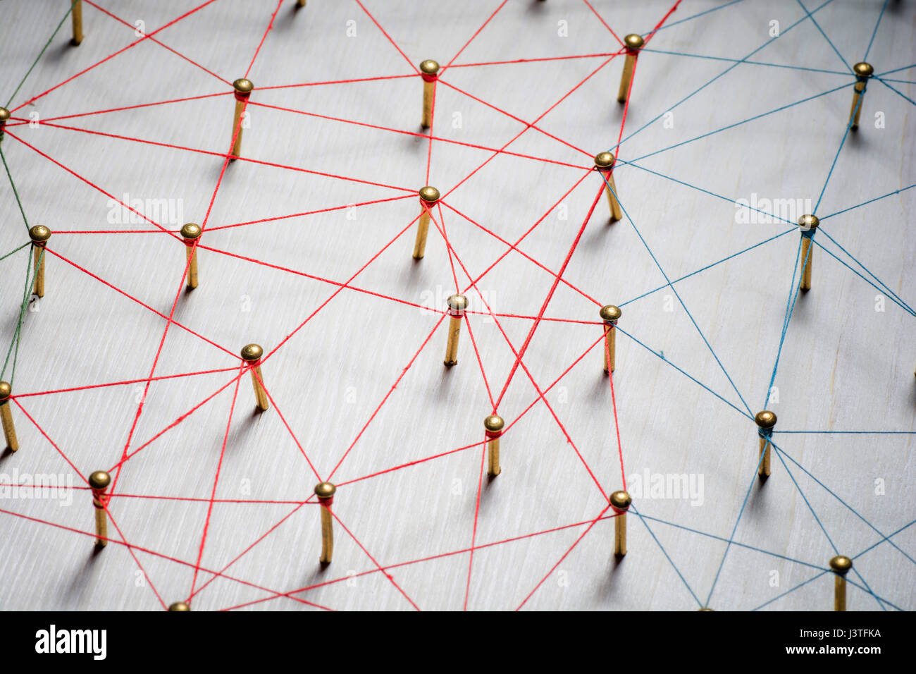 Linking entities. Network, networking, social media, internet communication abstract. A small connected to larger . Web of gold wires on rustic wood . Stock Photo