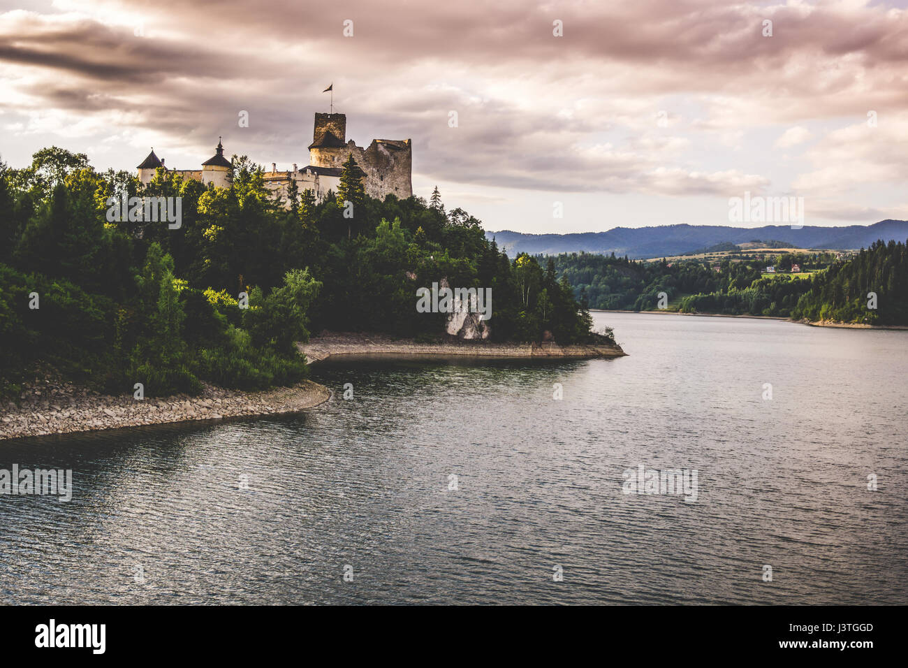 Niedzica castle on a hill by the Czorsztyn lake during a beautiful sunset. Stock Photo