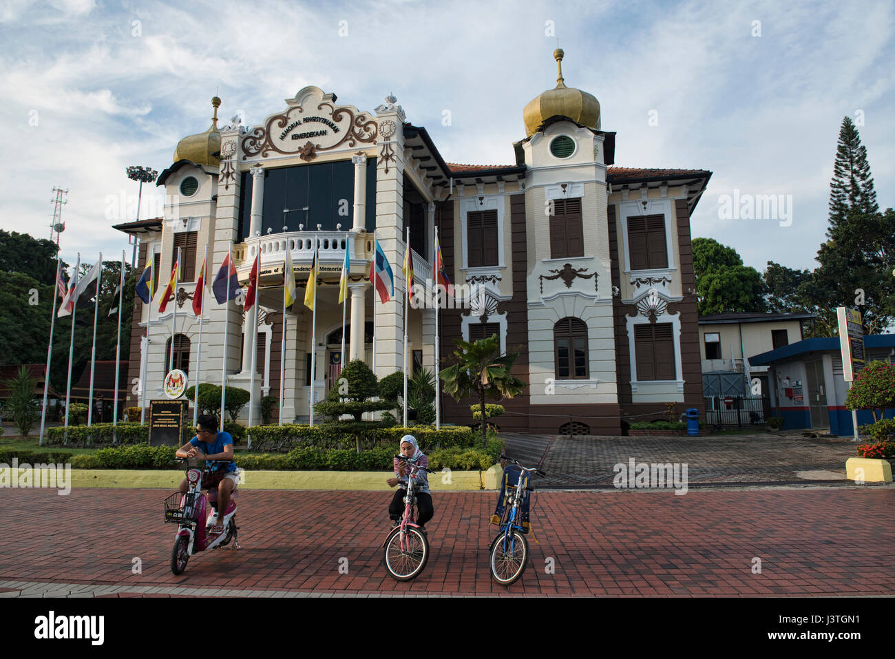 Cyclists in front of the Proclamation of Independence Memorial Museum, Malacca, Malaysia Stock Photo