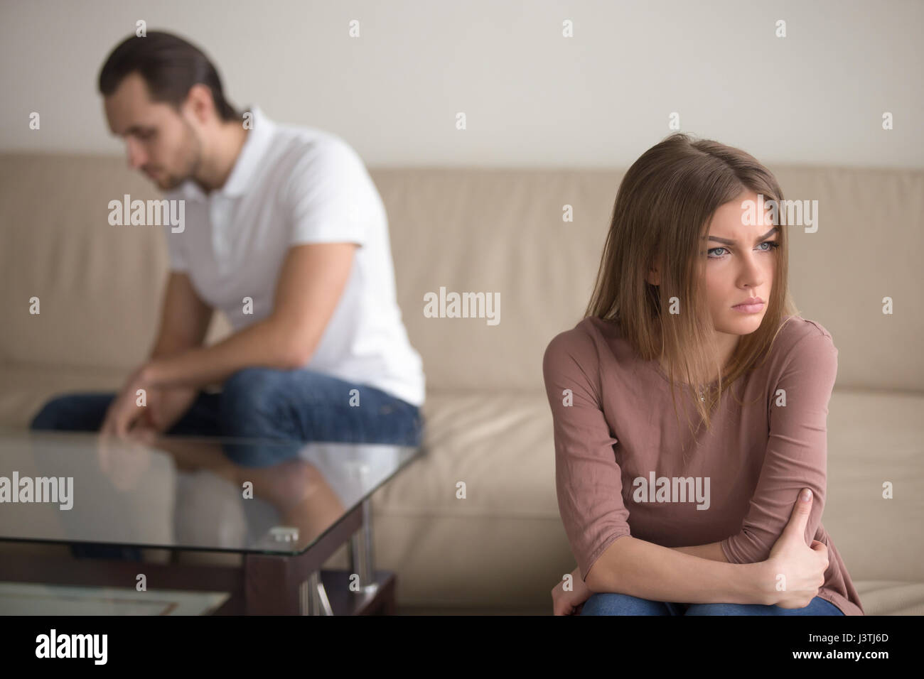 Unhappy thoughtful woman tired of quarrelling, upset man sitting Stock Photo