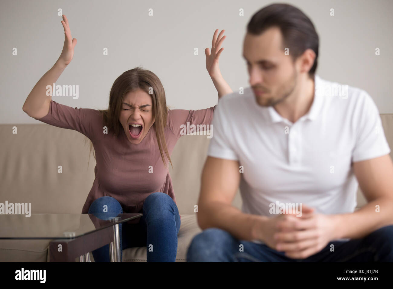 Young couple quarrelling, hysterical wife screaming at husband Stock