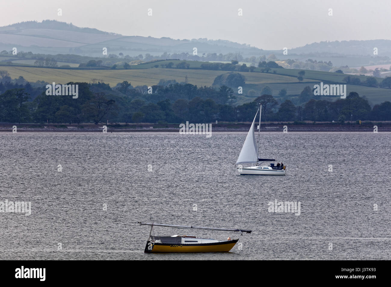 A sailing boat with two crew running before the wind with spinnaker