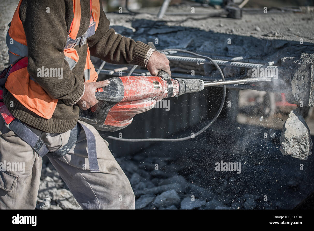 man using a jackhammer to drill into wall. professional worker in construction site Stock Photo