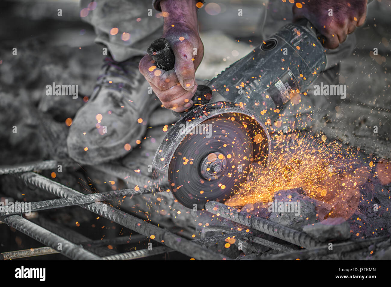 Construction worker cuts hollow steel square tube with circular saw Stock Photo