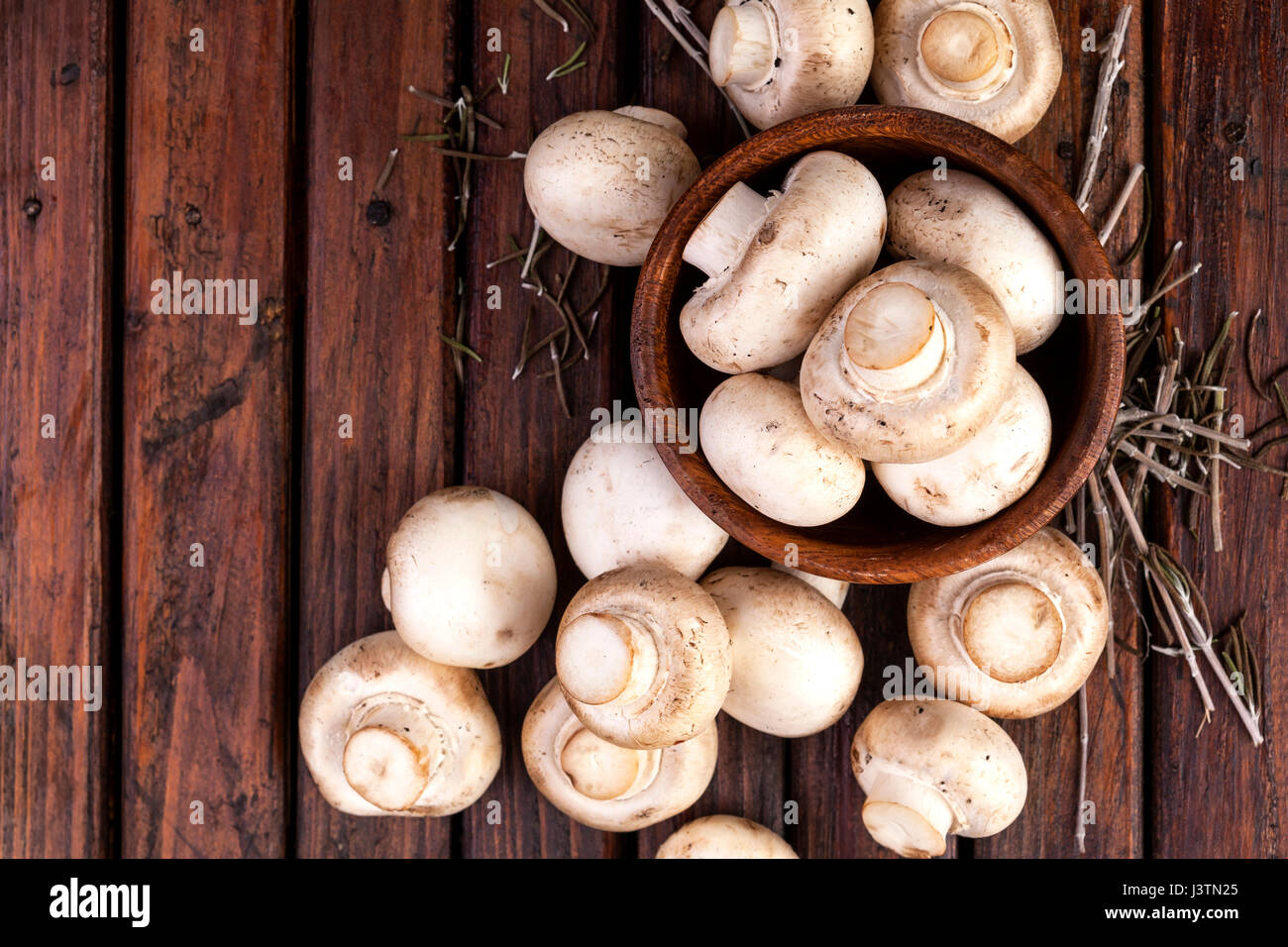 Mushrooms champignon on wooden background. Top view. Copy space. Stock Photo