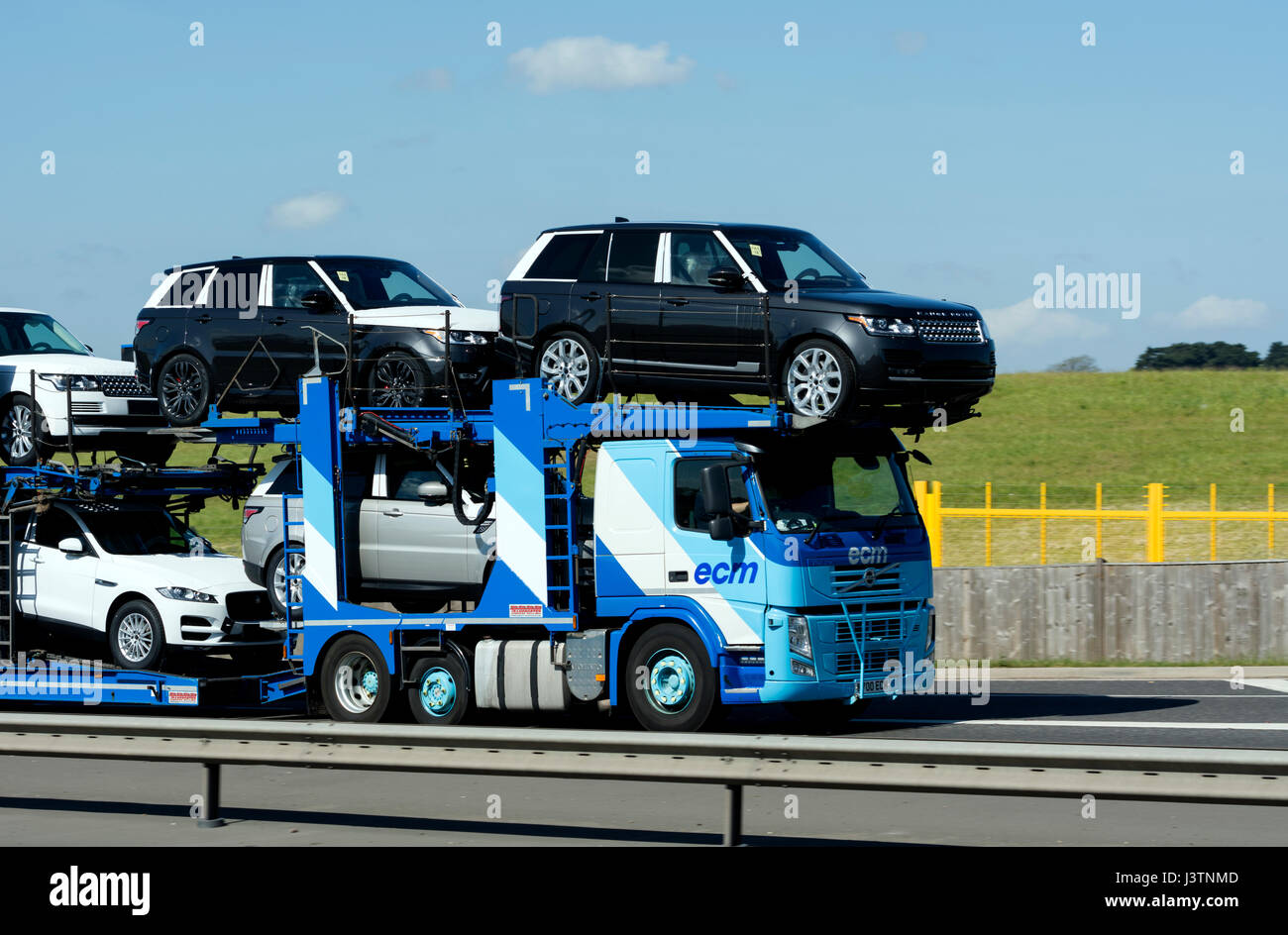 Car transporter carrying new Land Rover vehicles on the A45 road, West Midlands, UK Stock Photo