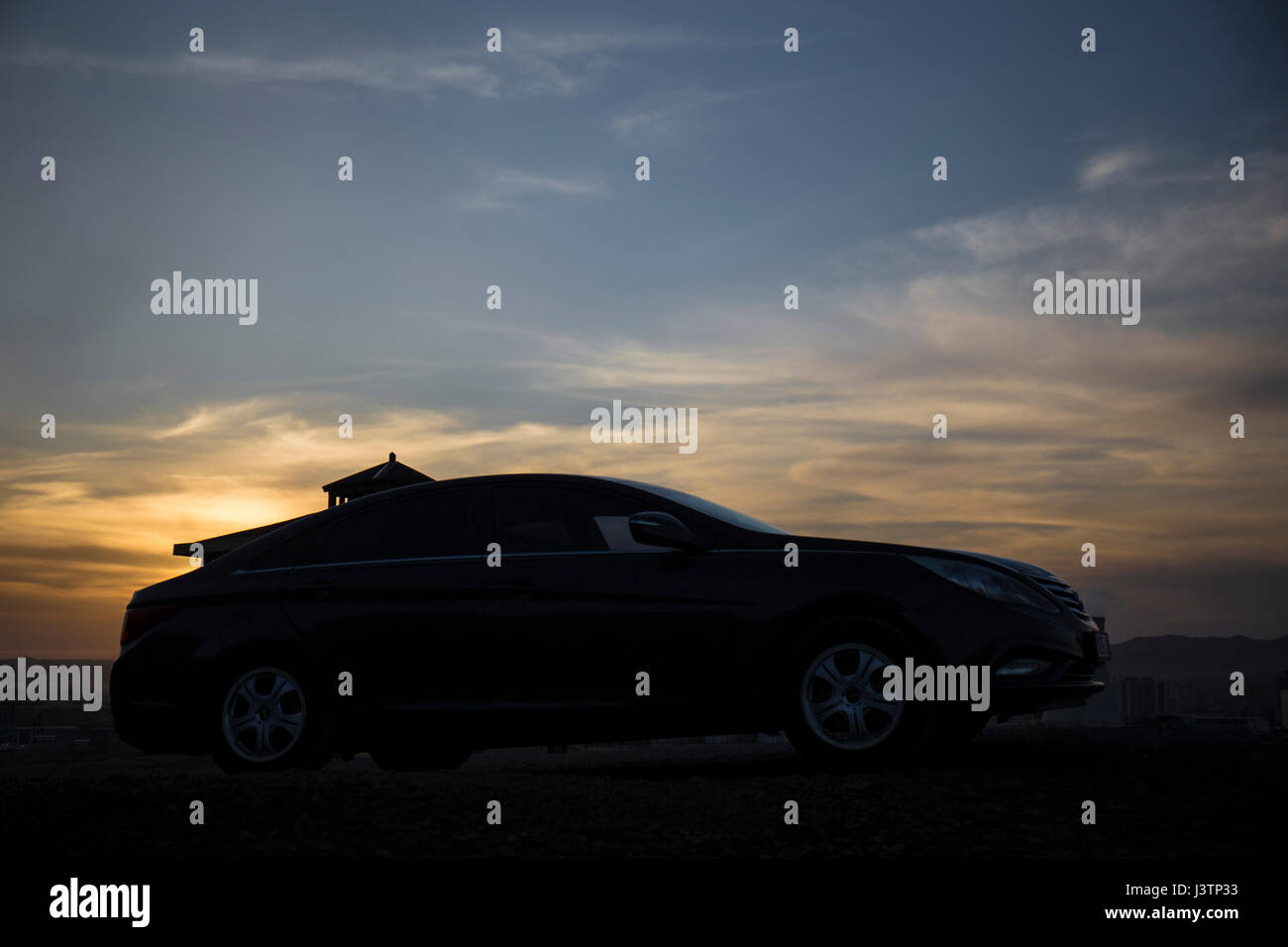 A luxury black car has just been touched by a beautiful sunset. Lookout at Ulan Bator Stock Photo