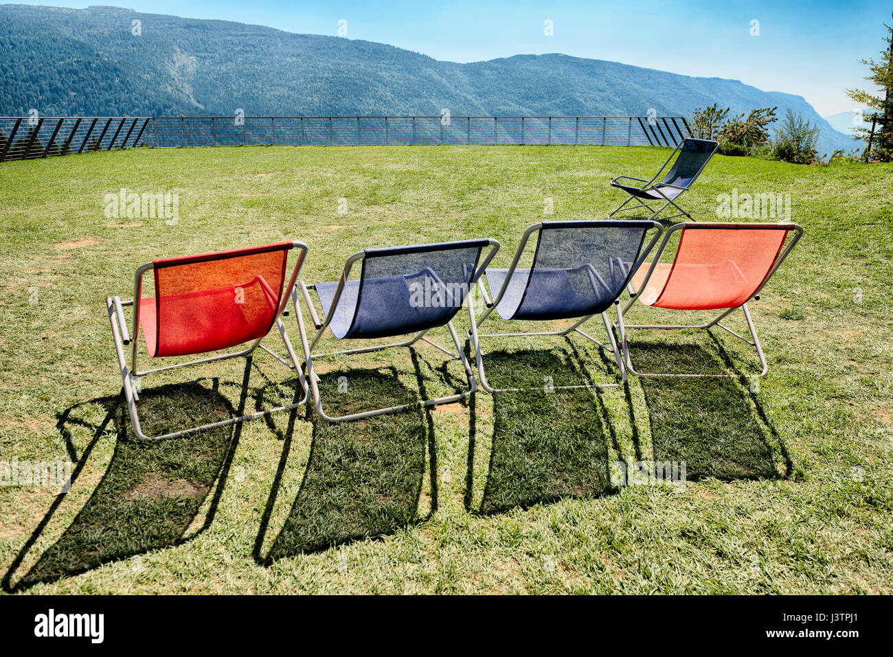 Five deck chairs on the terrace with panoramic mountain views Stock Photo