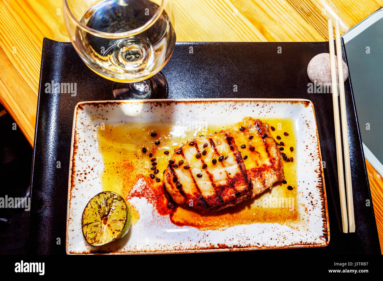 Japanese grilled fish in sweet agro orange sauce and sesame Stock Photo