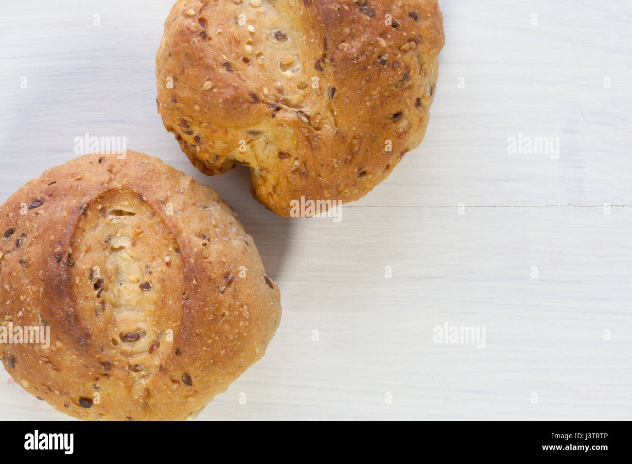 two cereal bread bun on white wood. Stock Photo