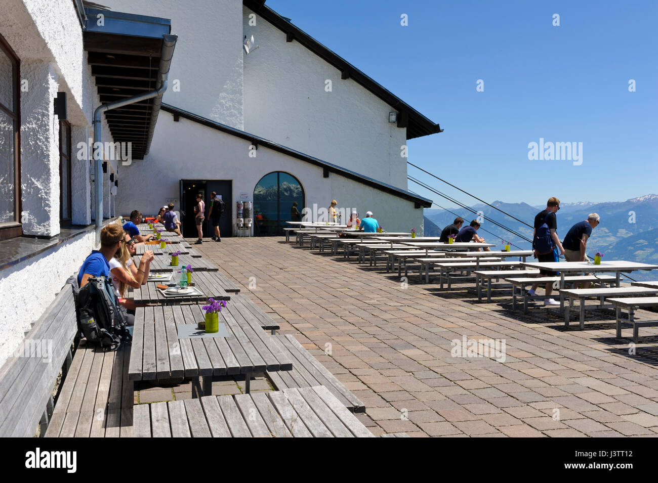 People sitting on wooden benches outside the restaurant at Seegrube