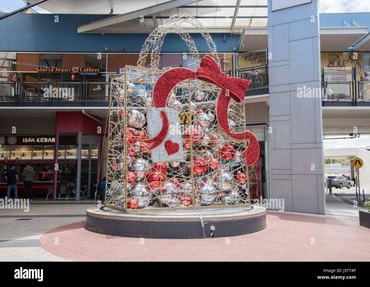 Large metallic silver and red package with ornaments and bow to