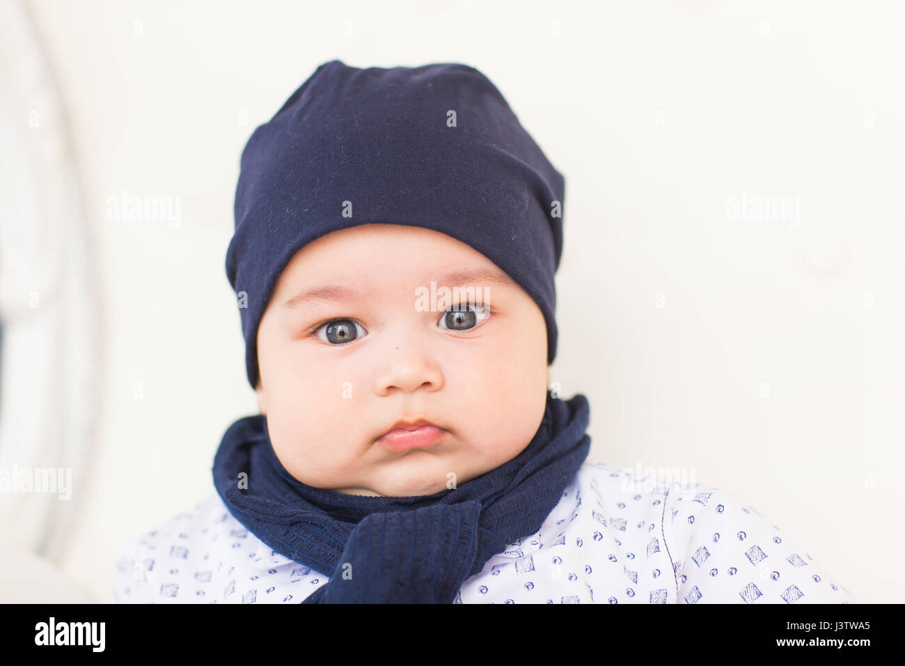 Close up portrait of cute baby boy wearing blue hat Stock Photo - Alamy