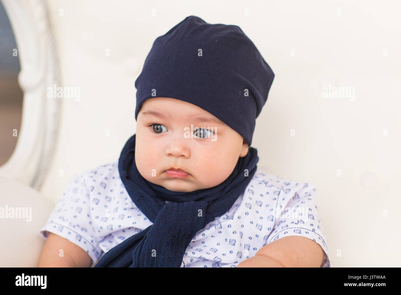 Close up portrait of cute baby boy wearing blue hat Stock Photo - Alamy